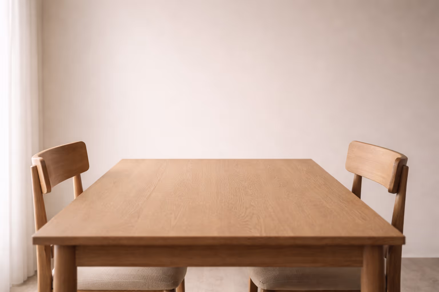  A simple wooden table with two empty chairs facing each other, seen from a slight distance, soft diffused light, neutral interior background, no objects on the table.