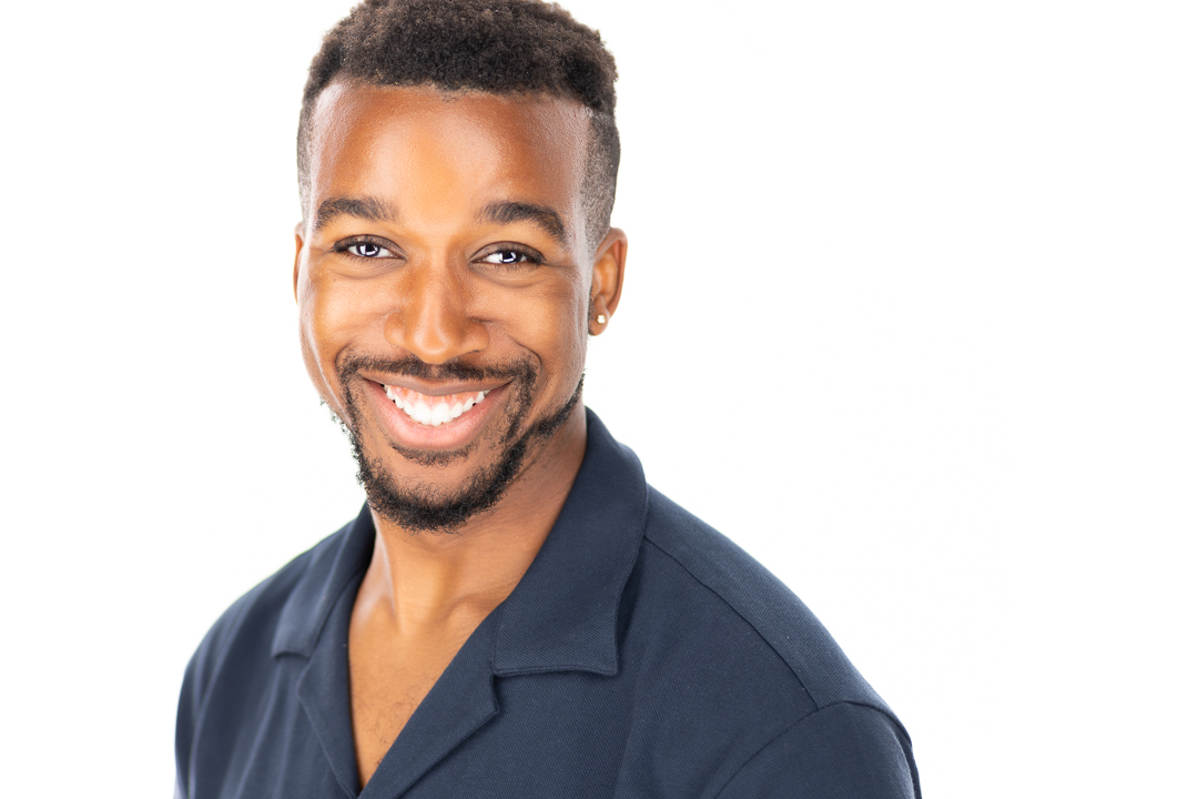 An example of a better Linkedin photo with a clear white background to keep focus on the genuine expression of this young man.