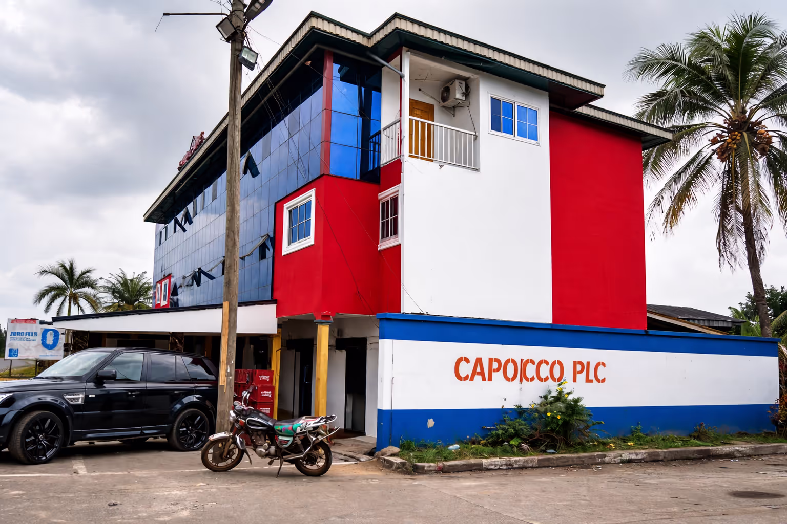 A wide shot of a luxurious hotel suite with a large window overlooking a beautiful landscape, emphasizing comfort and elegance at Hotel L'Empire Dibanda.
