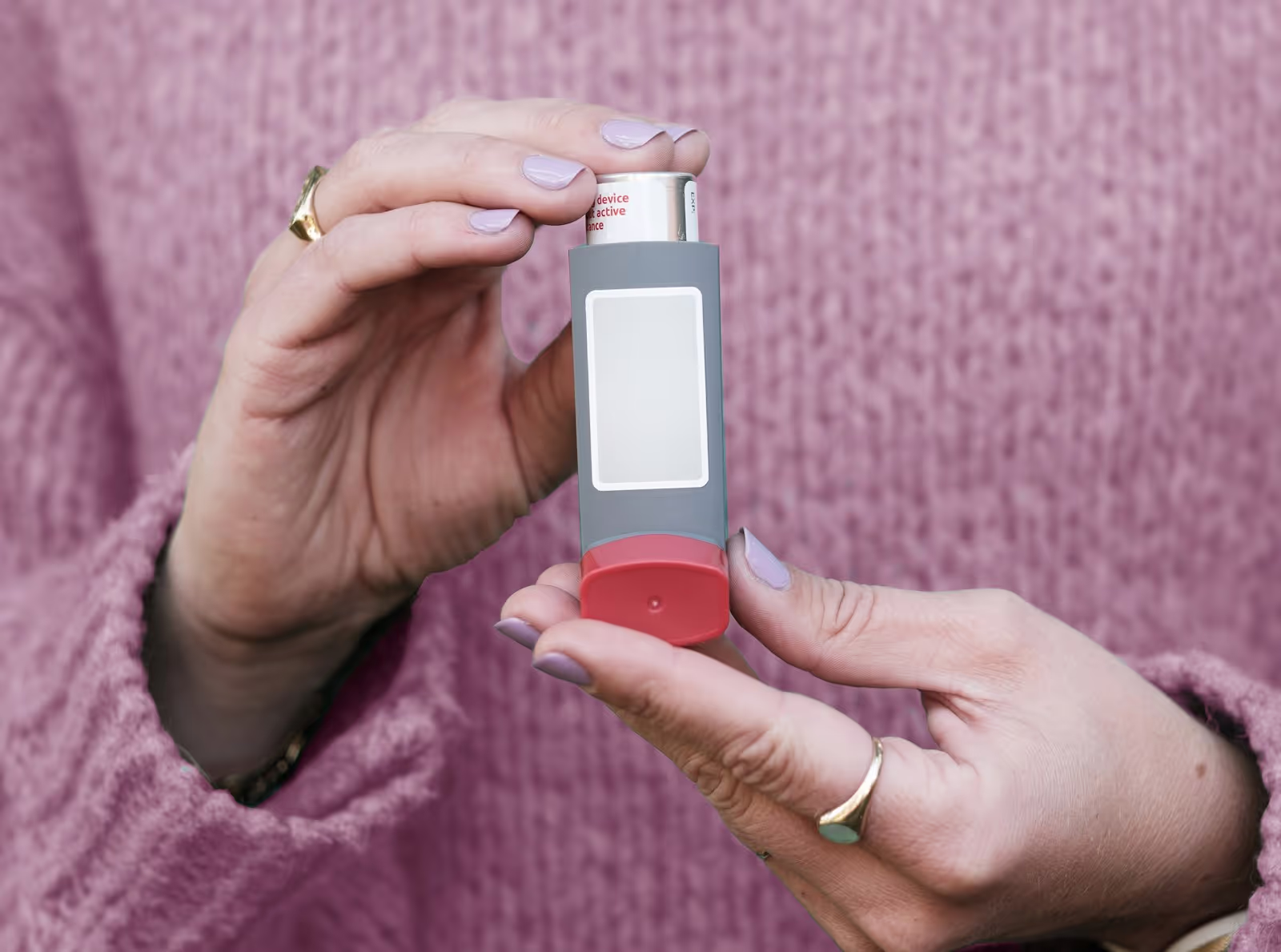 A person using an asthma inhaler
