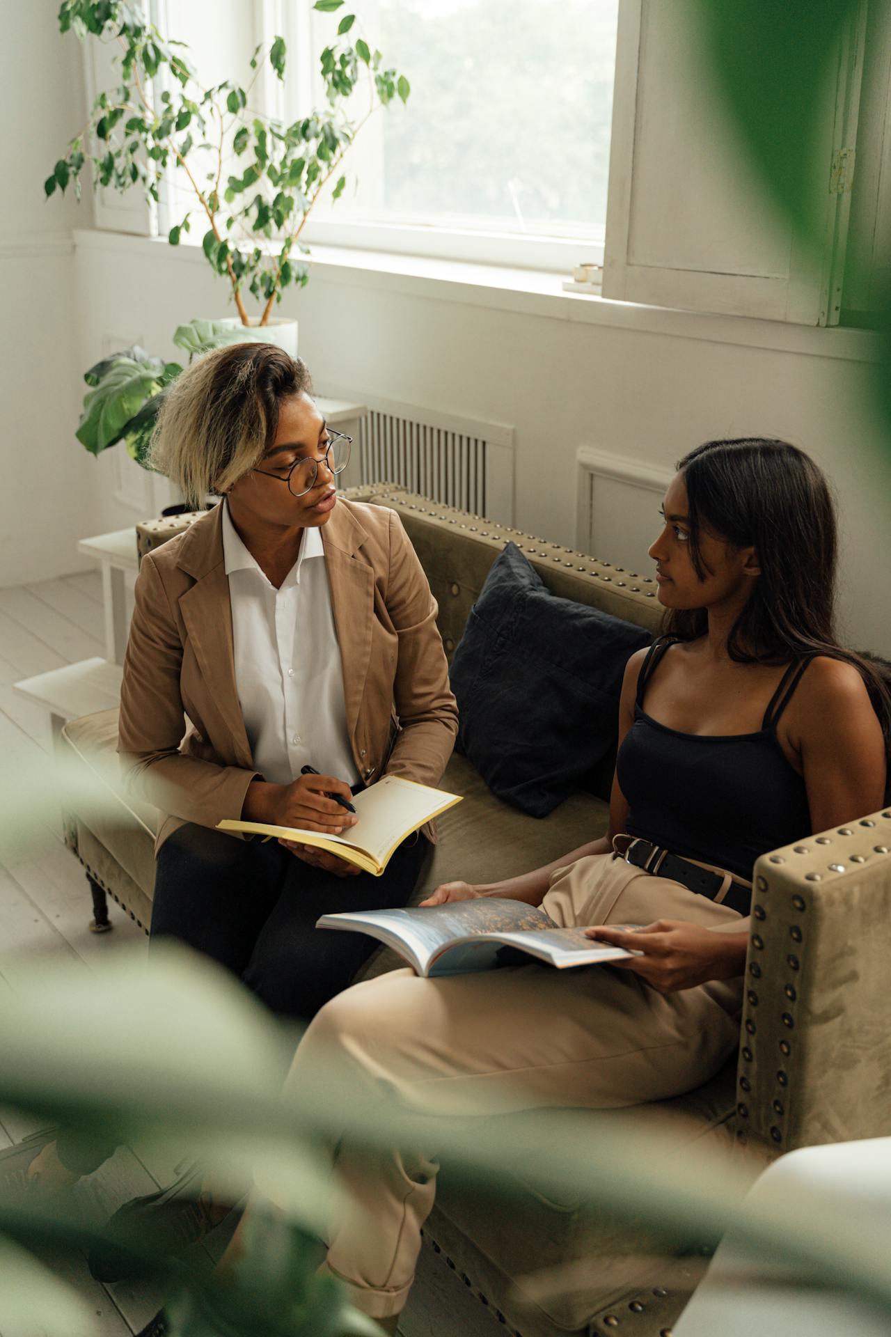 College student talking to a mental health counselor while sitting comfortably on a sofa, highlighting the importance of supporting college student mental health from distance.