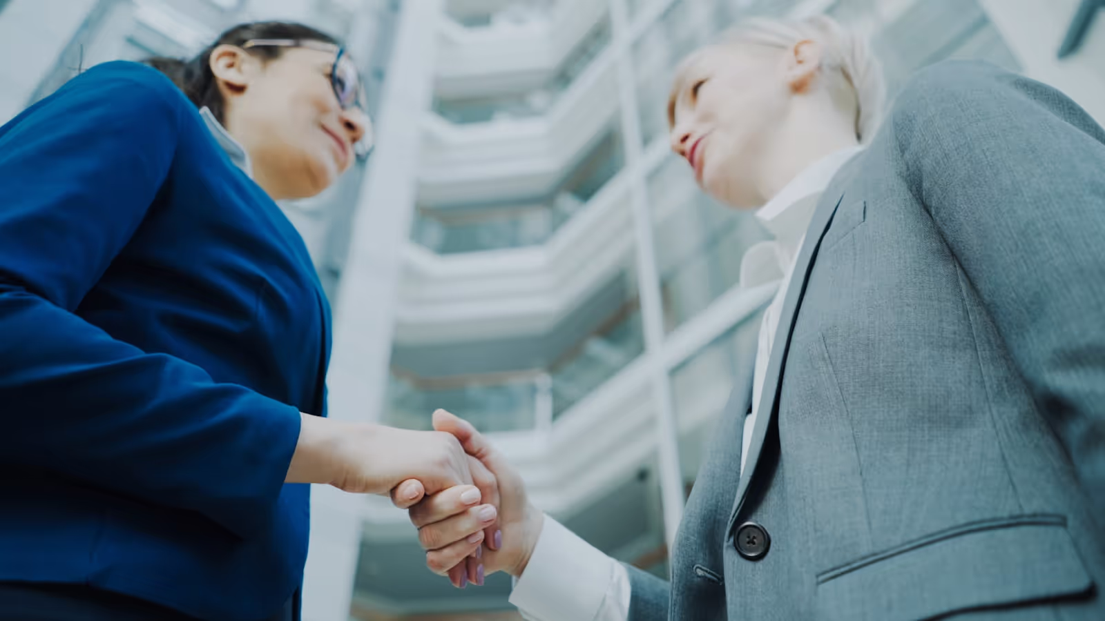 Professionals shaking hands in an office, symbolizing a business partnership.