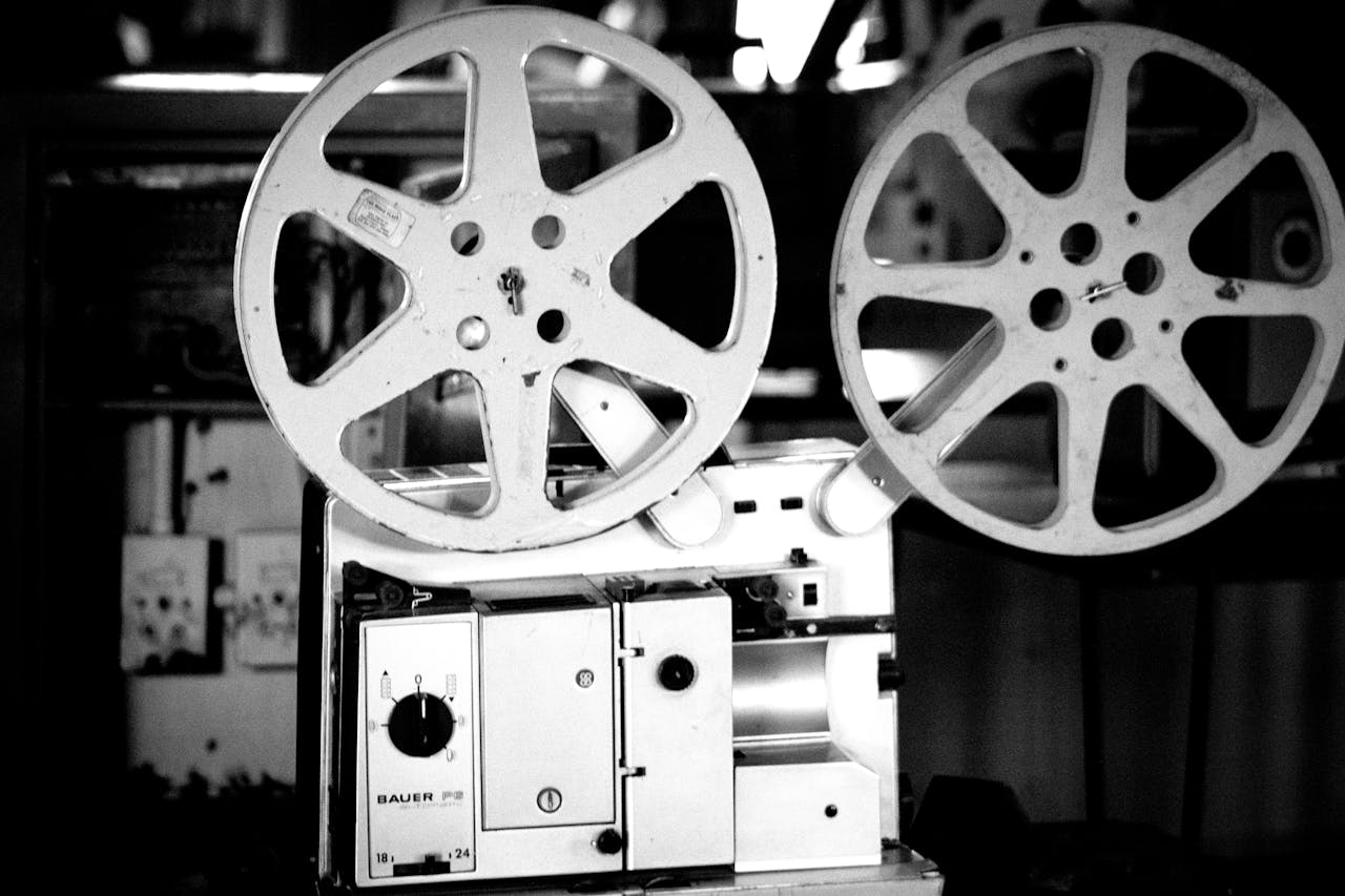 A black and white close-up of a vintage film projector with two large reels on top, featuring the 'BAUER P5' branding on the front.