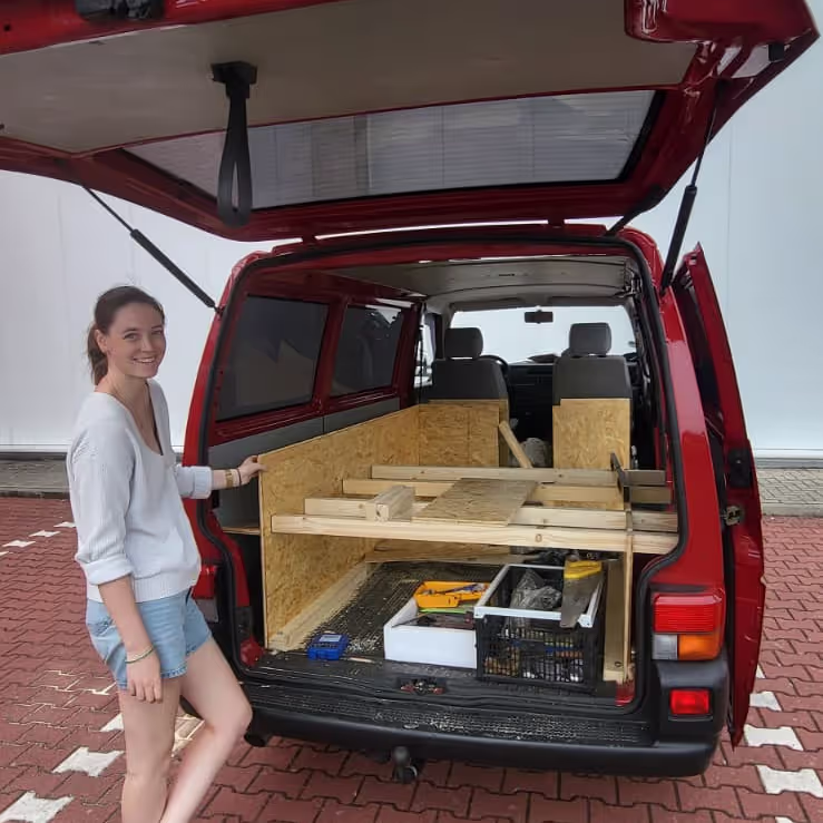 Caro standing at the back of our ban as we were building it in a Bauhaus Carpark Caro standing at the back of our ban as we were building it in a Bauhaus Carpark