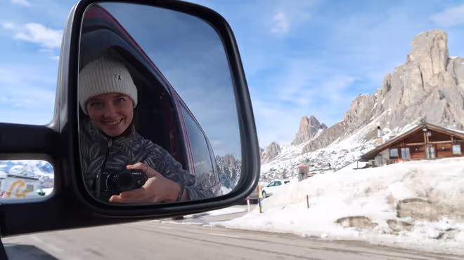 Caro taking a picture in the van mirror while driving through the mountain pass Caro taking a picture in the van mirror while driving through the mountain pass