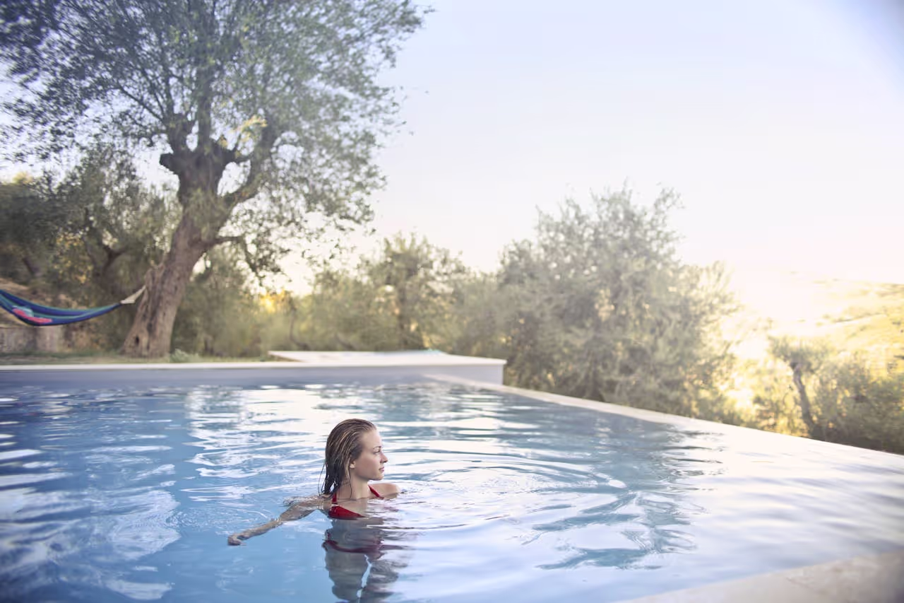 An outdoor swimming pool with a woman swimming in it