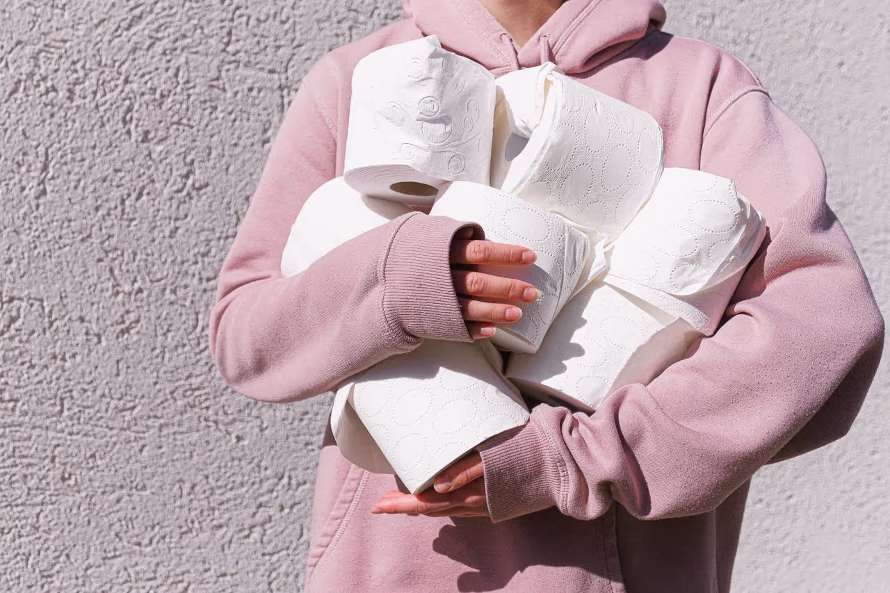 Woman holding up toilet paper rolls
