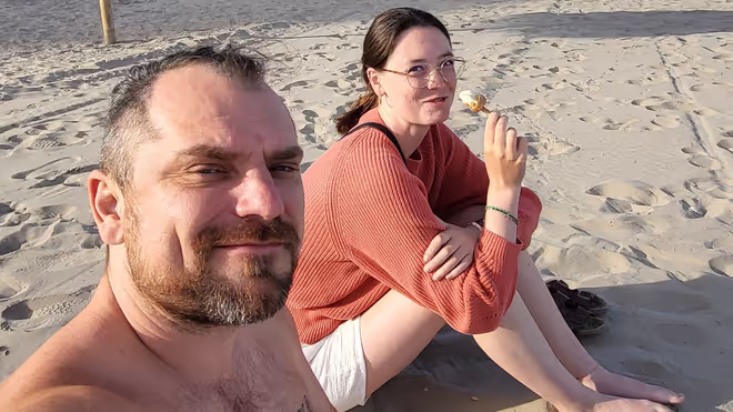Konrad and Caro sitting at a beach in Spain