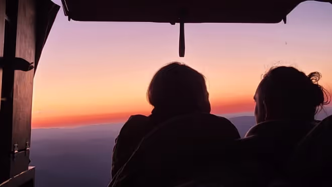 Konrad and Caro sitting in the back of their van during the sunset Konrad and Caro sitting in the back of their van during the sunset