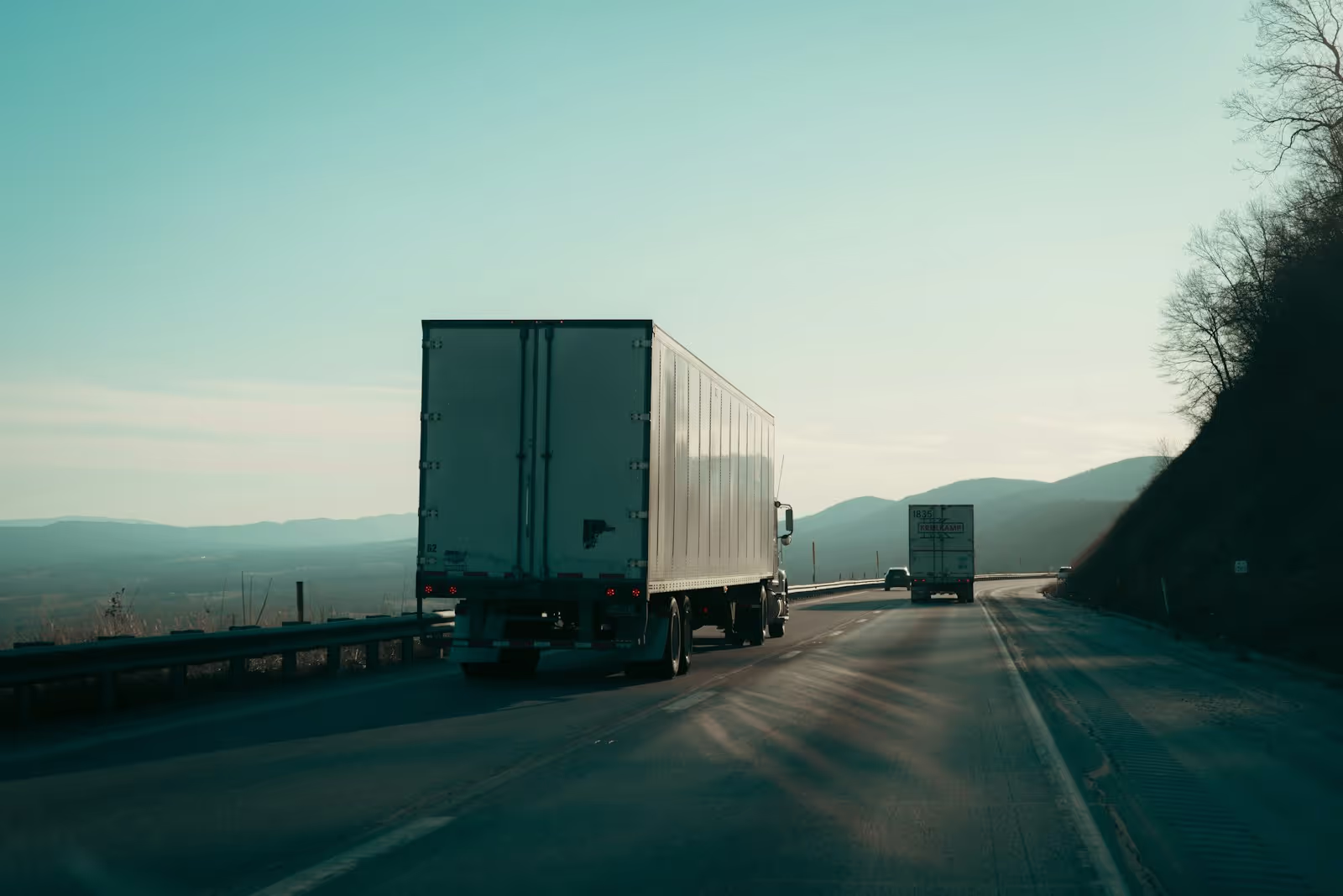 A modern semi-truck driving on a highway with a warm sunset glow, symbolizing efficient and reliable freight transport.
