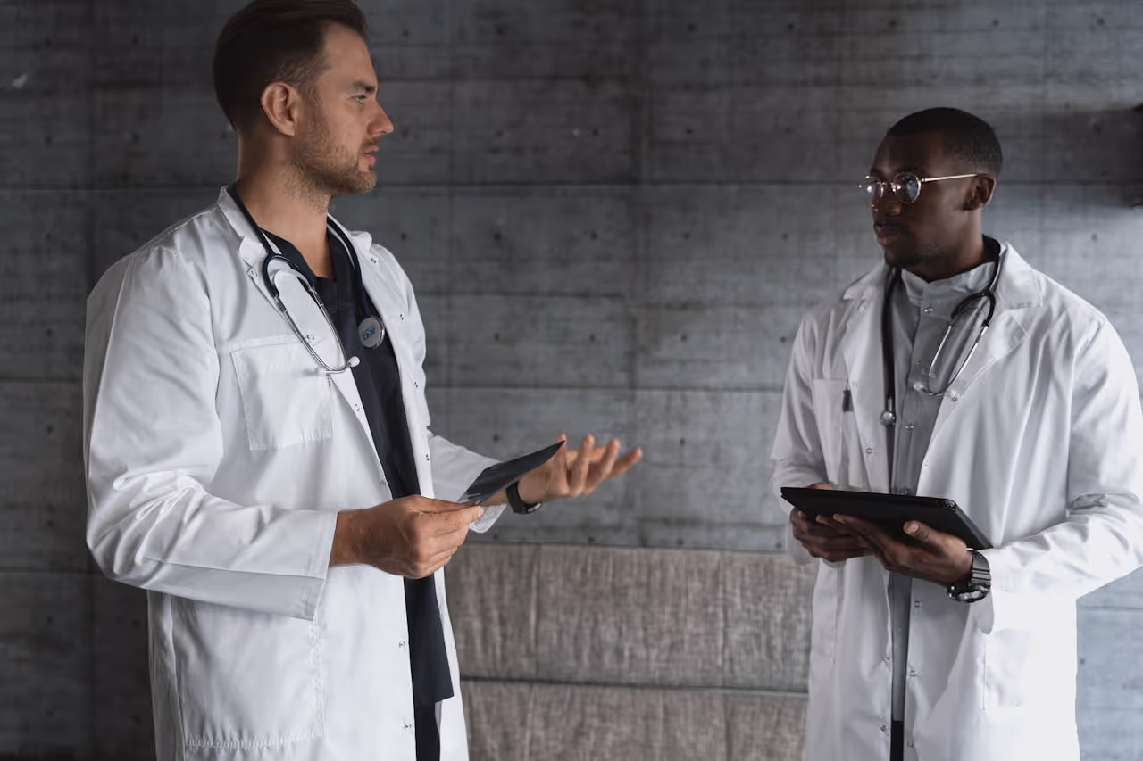 Two doctors in a modern workspace discussing patient care and medical research