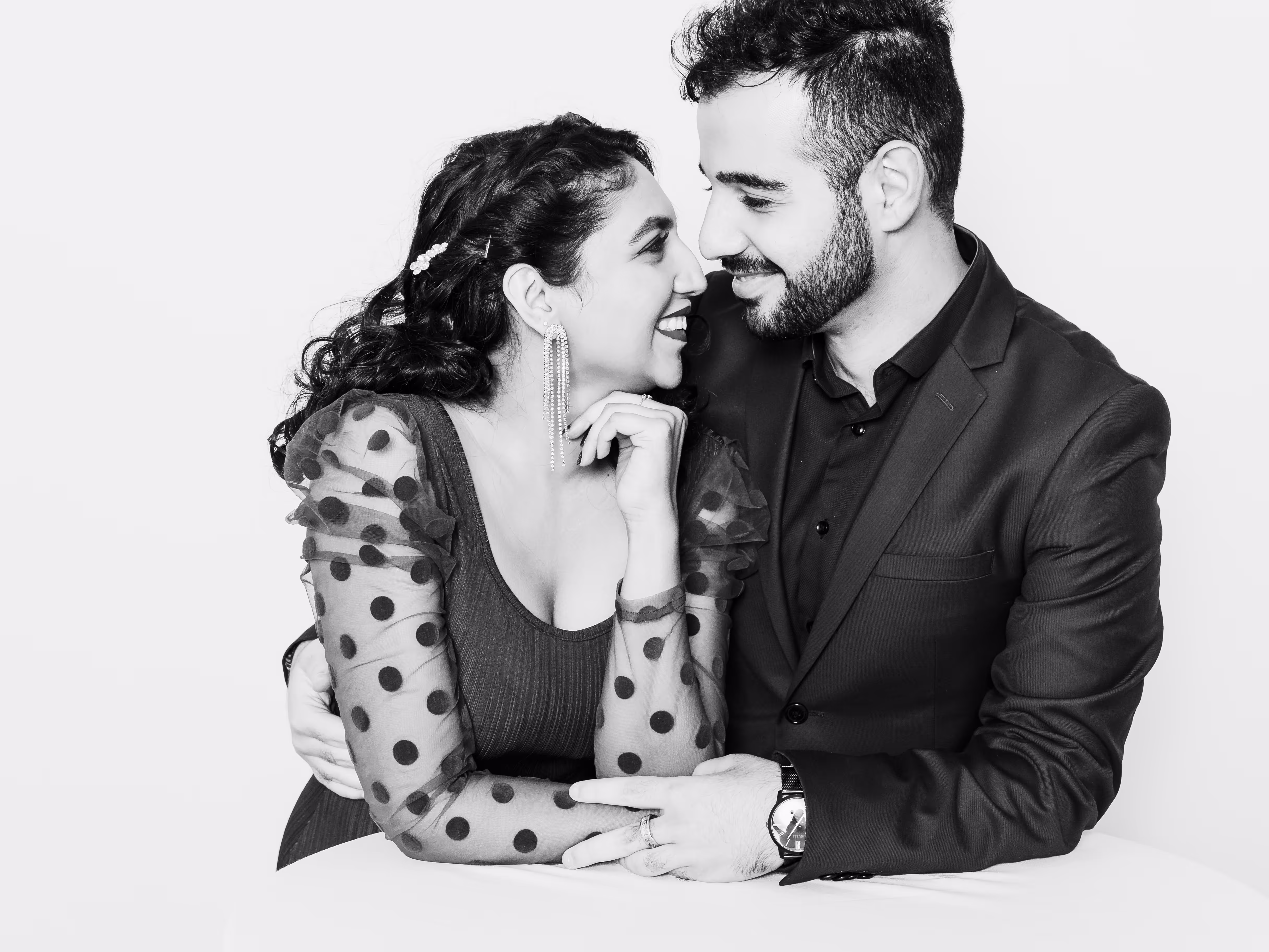 Indian couple looking lovingly into each other's eyes at their black and white photobooth